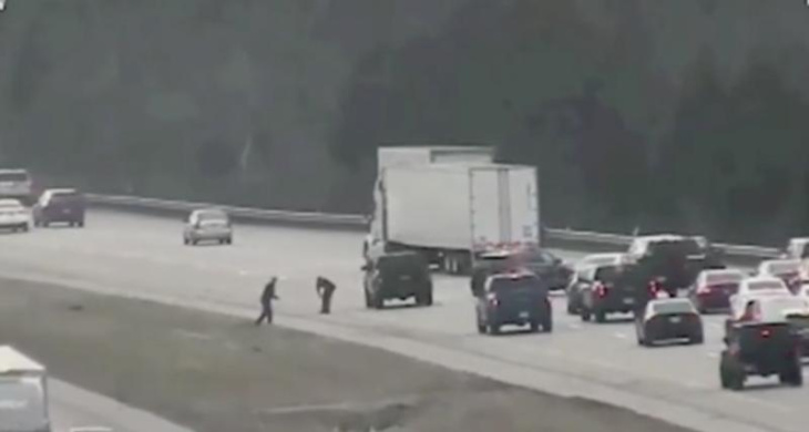les automobilistes s'arrêtent et descendent de voiture sur l'autoroute pour ramasser de l'argent
