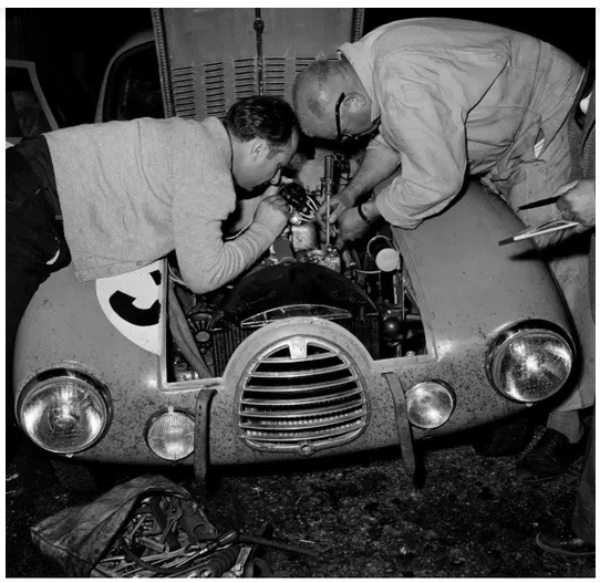 Fangio et son mécanicien, penchés sur leur Simca Gordini en 1950.