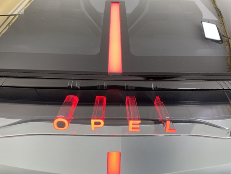 L'appellation Opel semble sortir du coffre grâce à un effet de lumière sur des lettres en 3D translucides.